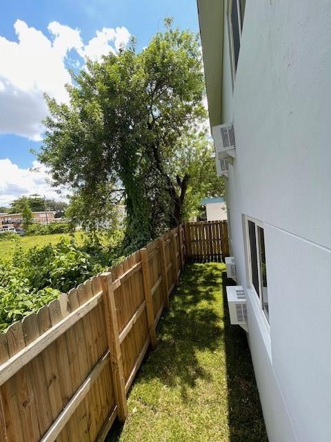 A wooden fence runs alongside a white building with two window air conditioning units — 1920 NW 151st St # 3, Opa-Locka FL 33054, OPA-LOCKA, FL