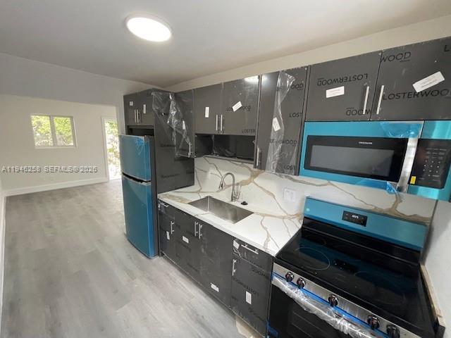 A modern kitchen features dark cabinets, stainless steel appliances, and white marble-patterned countertops — 1920 NW 151st St # 3, Opa-Locka FL 33054, OPA-LOCKA, FL