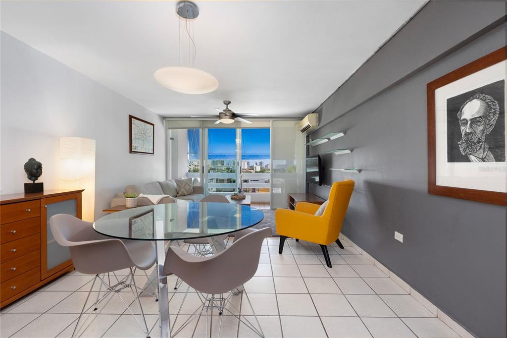 A living and dining area features a glass table, yellow armchair, and a balcony view — 251 CANALS STREET UNIT 401, SANTURCE, PR