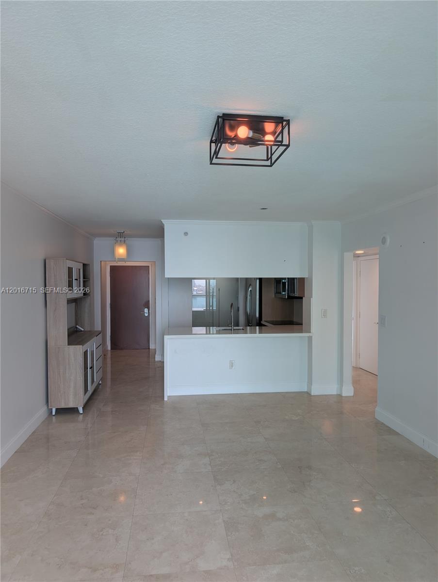 An open-concept living area features tile flooring, a kitchen with a breakfast bar, and lighting — 31 SE 5th St # 3002, Miami FL 33131, MIAMI, FL