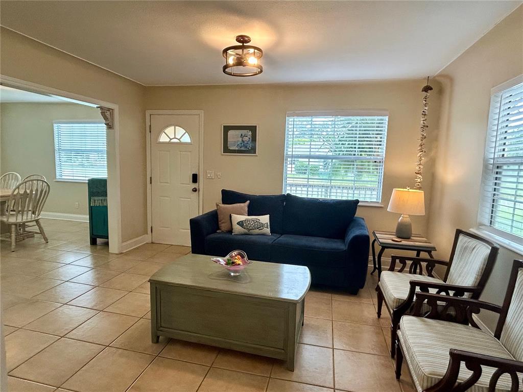 A living room features tile flooring, a blue sofa, two armchairs, and a coffee table — 5618 20TH AVENUE S, GULFPORT, FL