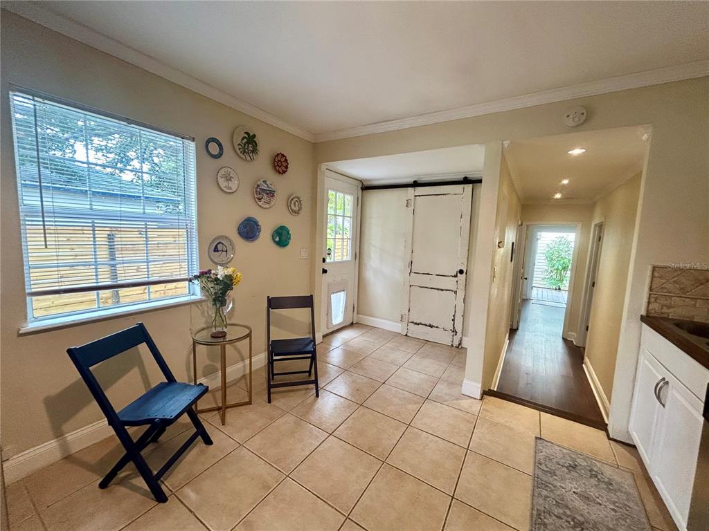 A tiled entryway features a window, decorative wall plates, two chairs, and a sliding door — 5618 20TH AVENUE S, GULFPORT, FL