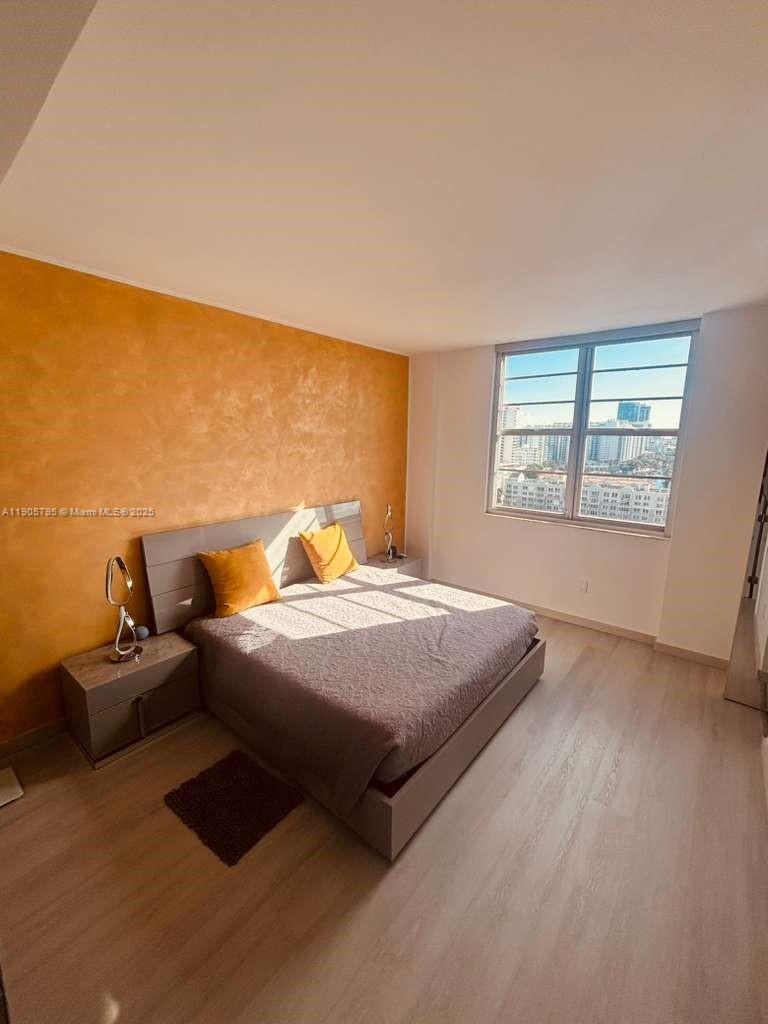 A bedroom features a bed with orange pillows against a textured orange accent wall — 2829 Indian Creek Dr # 1403, Miami Beach FL 33140, MIAMI BEACH, FL