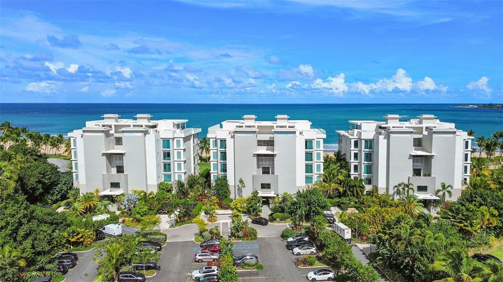 An aerial view of three multi-story apartment buildings surrounded by lush greenery and the ocean — 3101 OCEAN DRIVE, RIO GRANDE, PR