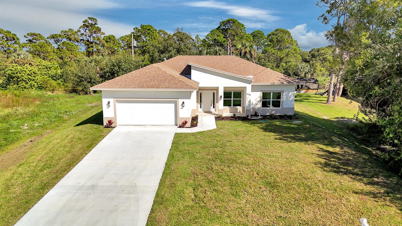 A single-story house with a white exterior, brown roof, and a concrete driveway — 5310 Sunset Boulevard, Fort Pierce FL 34982, FORT PIERCE, FL