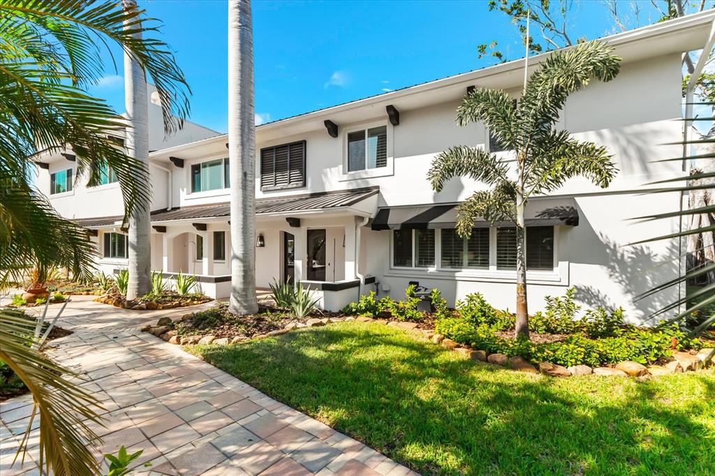 A two-story white house with a paved walkway, palm trees, and a grassy lawn — 16895 1ST STREET E, NORTH REDINGTON BEACH, FL