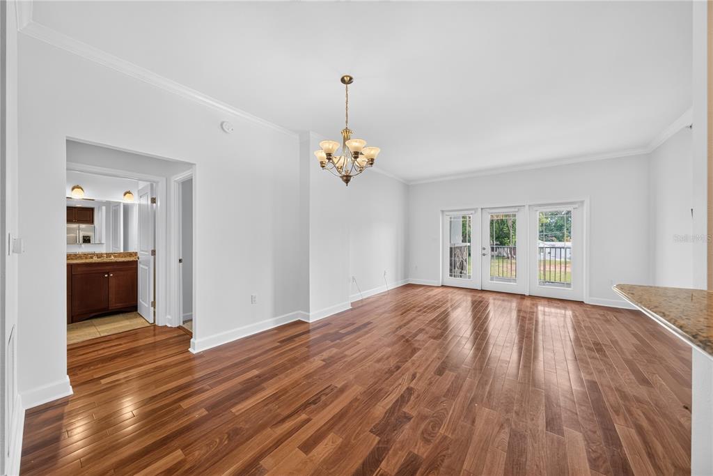 An empty dining room with hardwood floors, a chandelier, and glass doors leading outside — 630 VASSAR STREET UNIT 2210, ORLANDO, FL