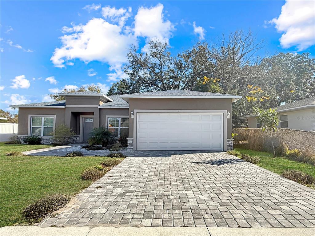 A single-story house with a paved driveway, a two-car garage, and a gray exterior — 141 SCOTT DRIVE, SANFORD, FL