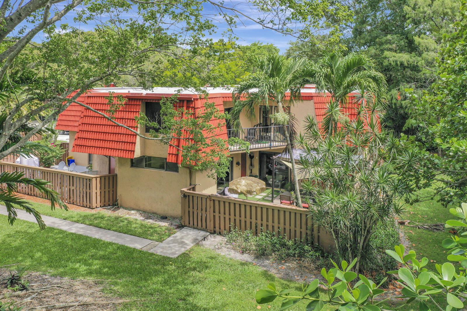 A two-story building with a red mansard roof and tan stucco walls features fenced patios — 8105 Severn Drive # C, Boca Raton FL 33433, BOCA RATON, FL