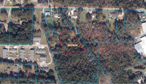 An aerial map shows a highlighted rectangular plot of land surrounded by trees and buildings — 100 W STATE LINE ROAD, CENTURY, FL