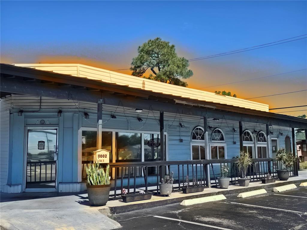 A light blue commercial building features a covered porch, arched windows, and a parking lot — 11002 SEMINOLE BOULEVARD, LARGO, FL