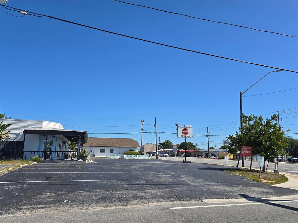 An asphalt parking lot sits in front of a commercial building under a clear sky — 11002 SEMINOLE BOULEVARD, LARGO, FL