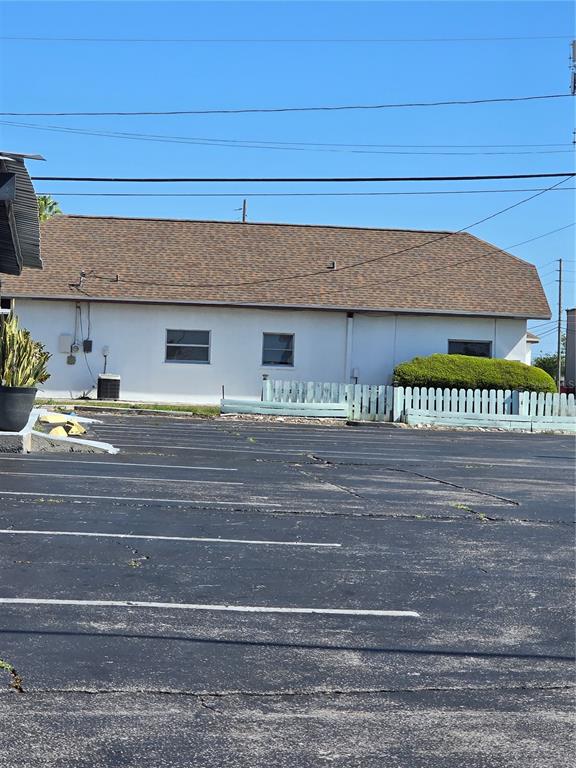 The exterior of a single-story building features a brown shingled roof and a parking lot — 11002 SEMINOLE BOULEVARD, LARGO, FL