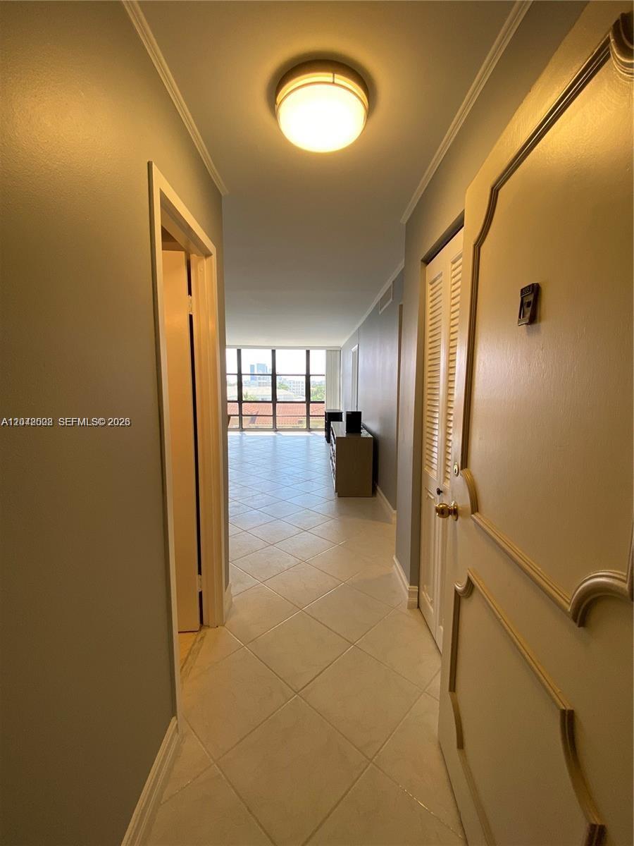 A hallway with tile flooring leads to a living area with floor-to-ceiling windows — 2049 S Ocean Dr # 503, Hallandale Beach FL 33009, HALLANDALE BEACH, FL