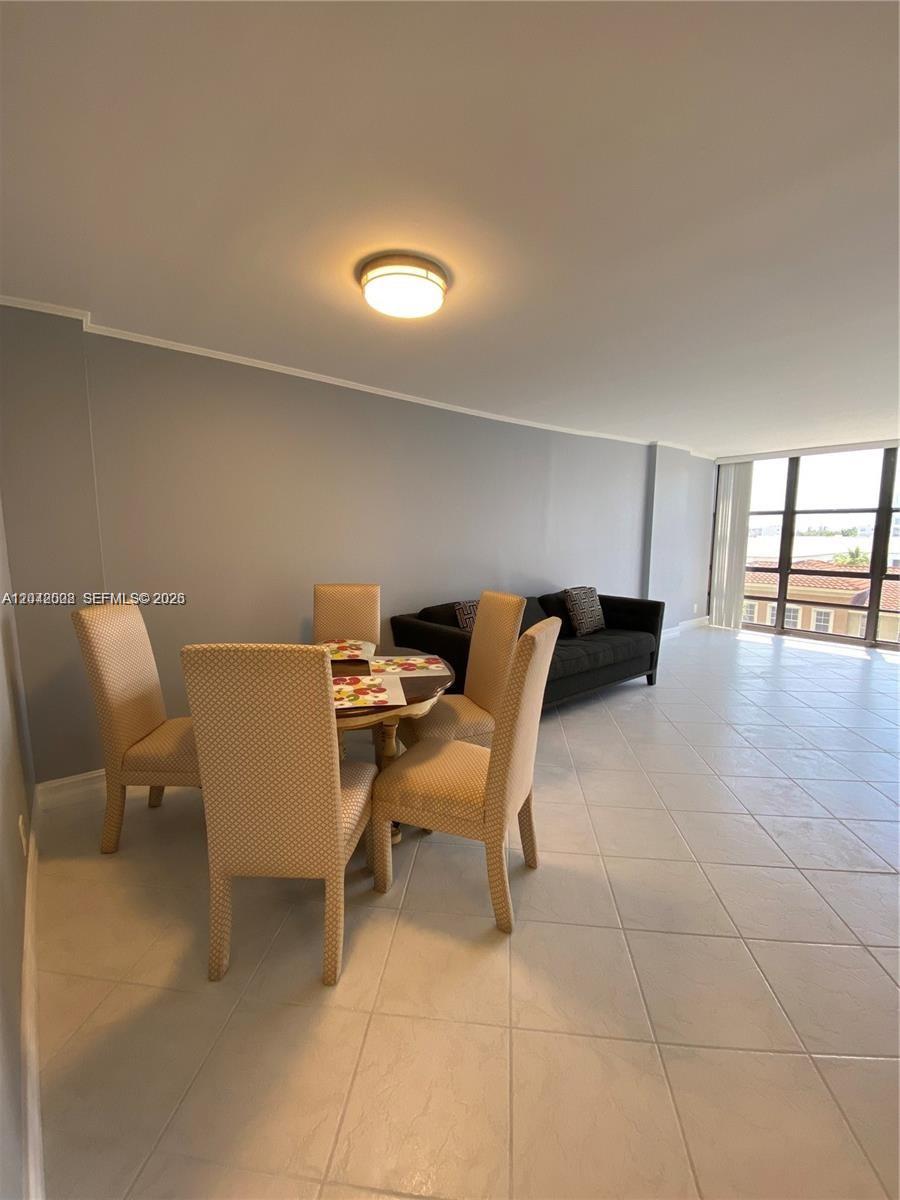 A dining area with a round table and four chairs sits next to a living space — 2049 S Ocean Dr # 503, Hallandale Beach FL 33009, HALLANDALE BEACH, FL