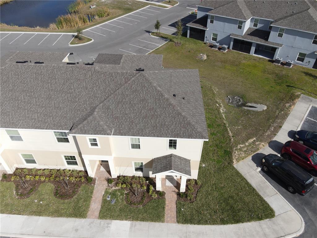 An aerial view shows a two-story residential building with a shingled roof and parking — 435 ANNABELLE WAY, DAVENPORT, FL