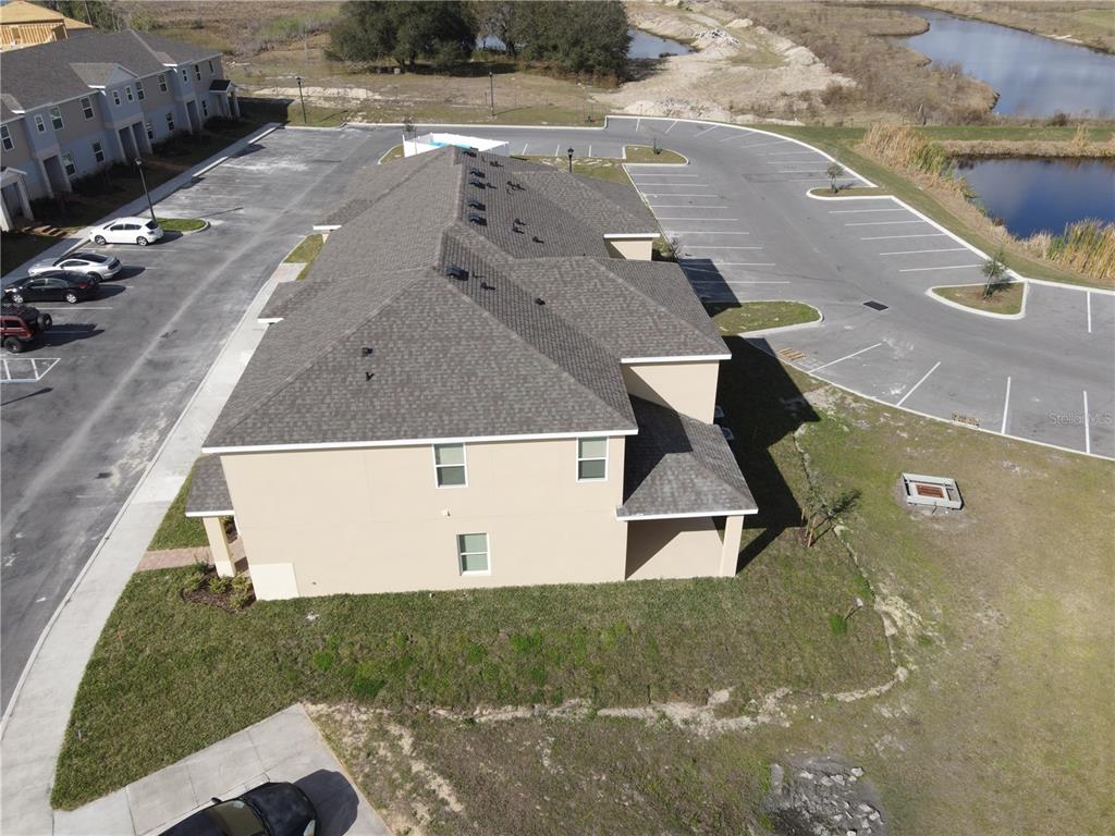 An aerial view shows a multi-story tan building with a gray roof and parking lots — 435 ANNABELLE WAY, DAVENPORT, FL