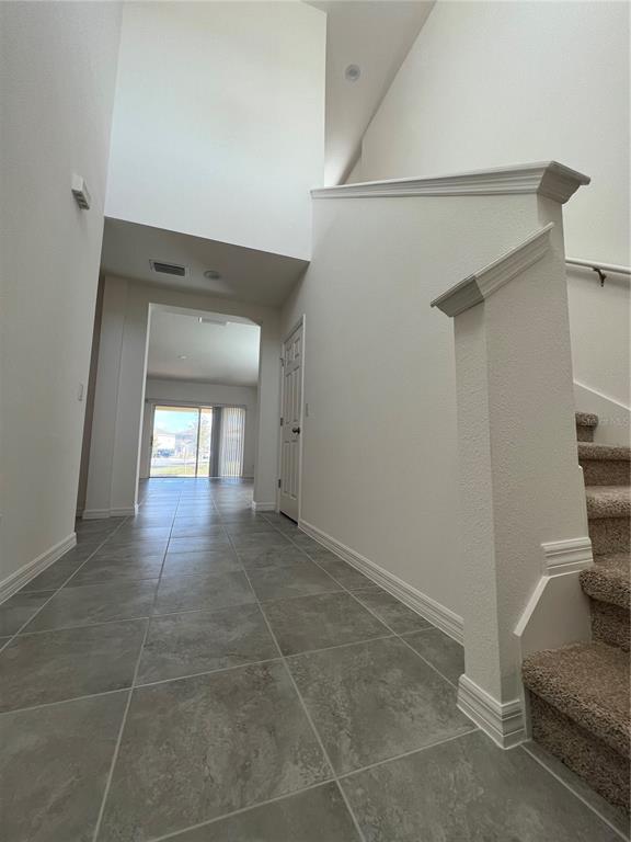 A tiled entryway leads to a living area with a staircase and high ceilings — 435 ANNABELLE WAY, DAVENPORT, FL
