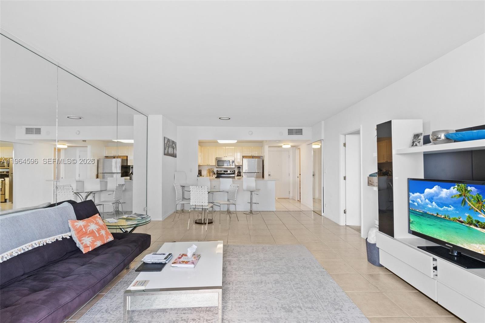 A living room with a dark sofa, white coffee table, and an open kitchen area — 2301 Collins Ave # 504, Miami Beach FL 33139, MIAMI BEACH, FL