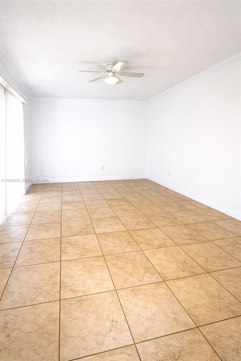 An empty room features white walls, a ceiling fan, and light brown tiled flooring — 6713 SW 112th Ct, Miami FL 33173, MIAMI, FL