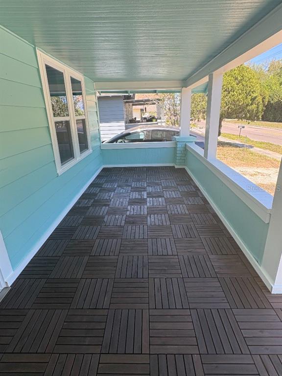A covered porch features light blue siding, white trim, and dark wood-look interlocking deck tiles — 408 N MARTIN LUTHER KING JR AVENUE, CLEARWATER, FL