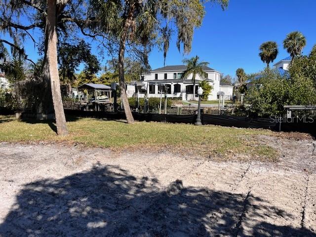 A view of a sandy lot with trees and a large house in the background — 2640 S DUNDEE STREET, TAMPA, FL