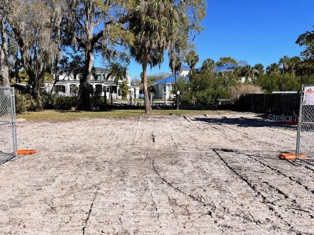 A cleared, sandy residential lot is framed by chain-link fencing under a clear blue sky — 2640 S DUNDEE STREET, TAMPA, FL