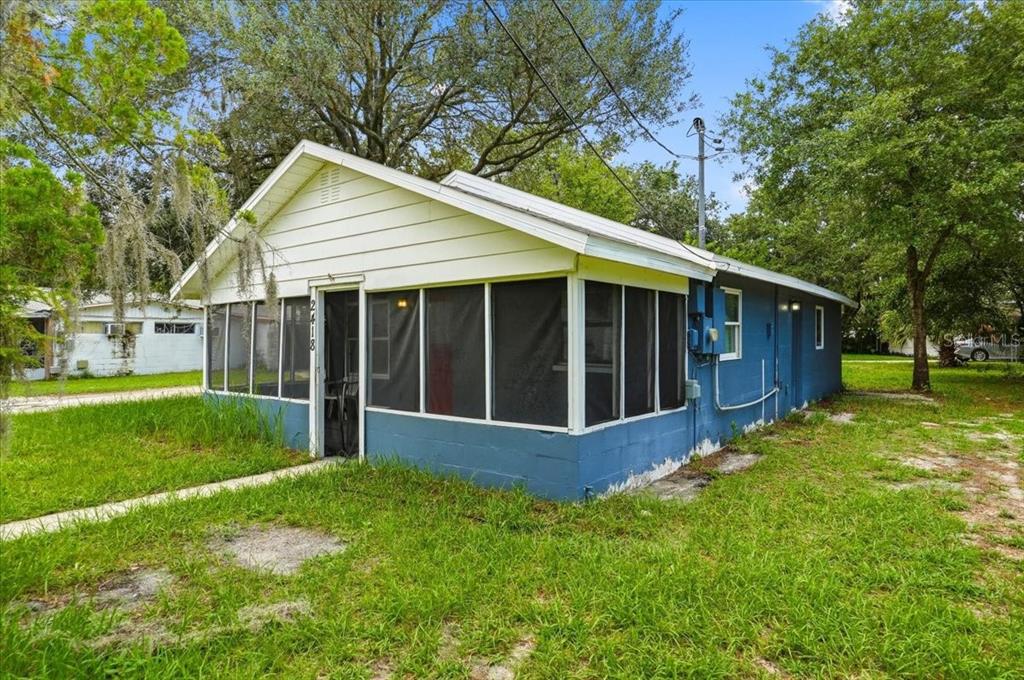 A screened-in porch with a concrete floor, blue painted walls, and views of a neighborhood — 2418 JUNGLE STREET, LAKELAND, FL