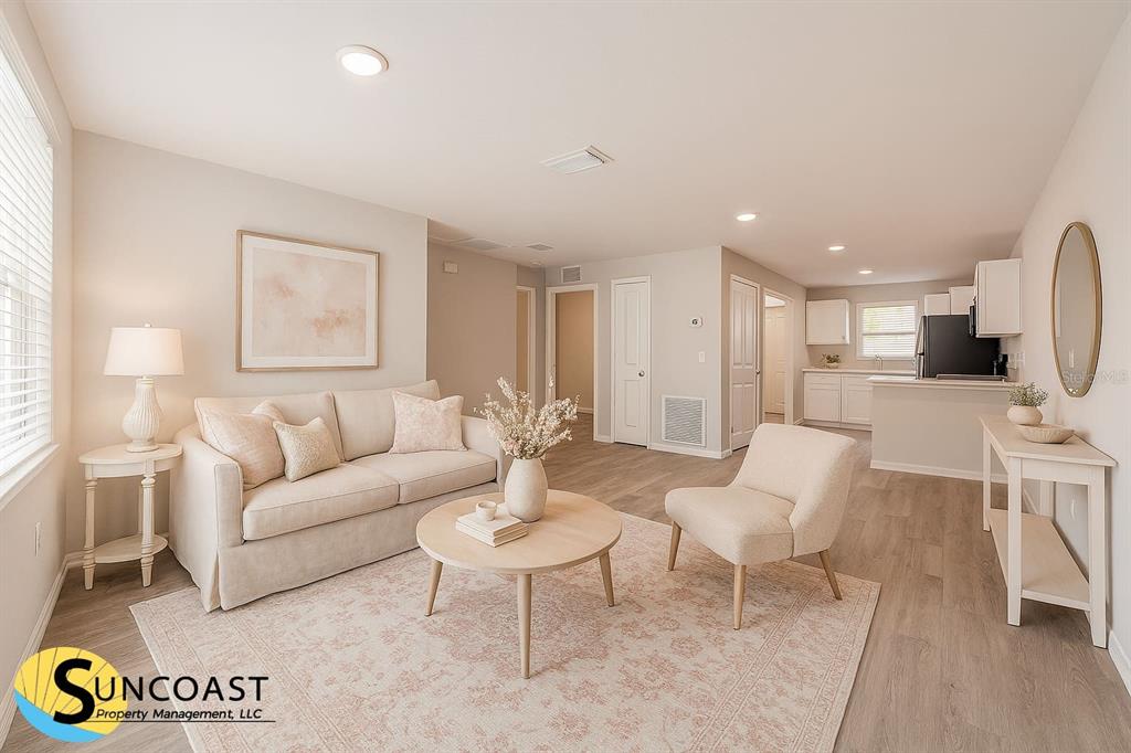 A living room with light-colored furniture, a round coffee table, and wood-look flooring — 15845 SW 33RD AVENUE ROAD, OCALA, FL