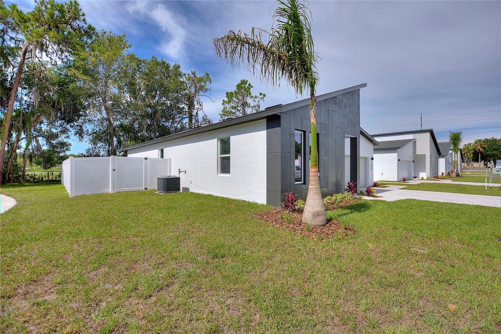 A modern white and dark gray house exterior with a palm tree in the yard — 24479 SW KINGSWAY CIRCLE, ARCADIA, FL