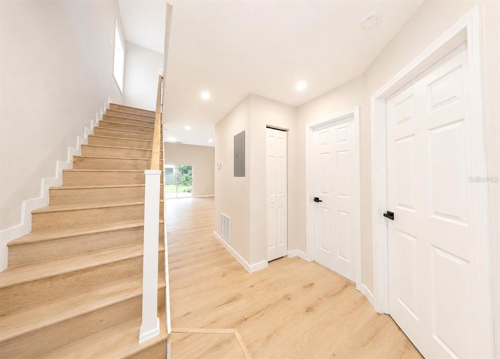 A staircase with light wood steps leads to an upper level near a white hallway — 1141 WOODMAN WAY, ORLANDO, FL