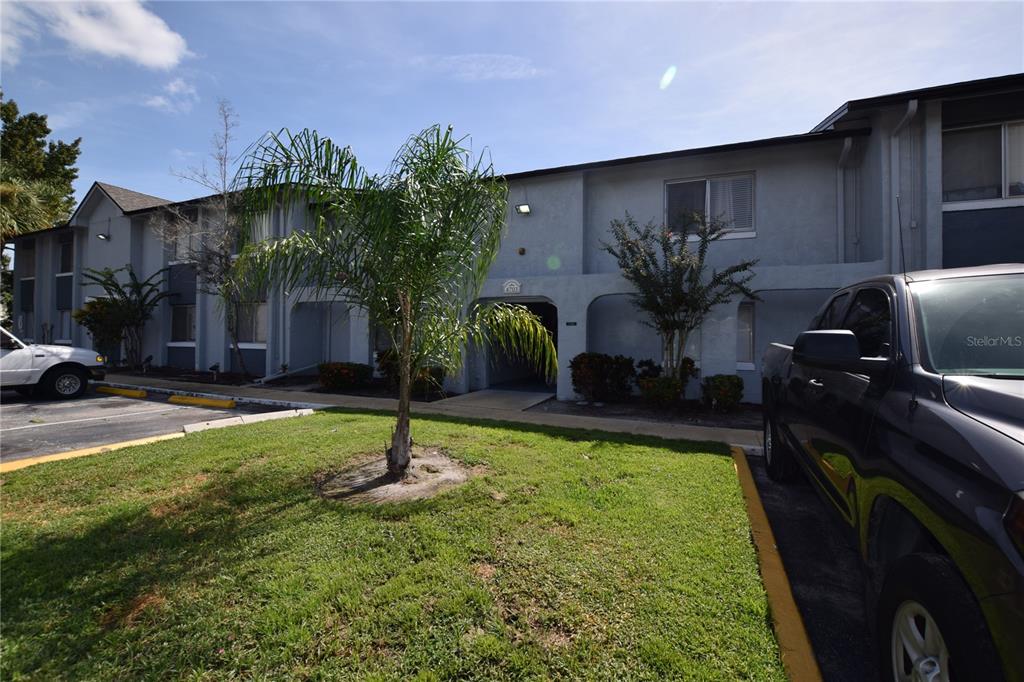 A two-story apartment building exterior features a central entryway, a palm tree, and parking spaces — 4703 S TEXAS AVENUE UNIT 4703A, ORLANDO, FL