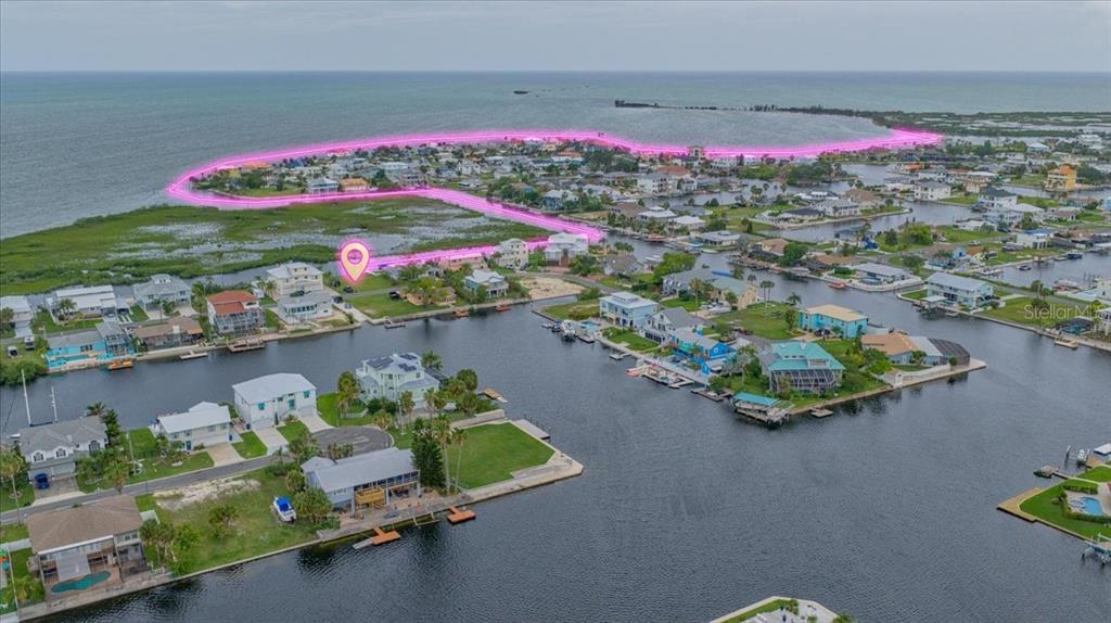 An aerial view shows a waterfront neighborhood with houses along canals and a highlighted property — 4181 ORCHID DRIVE, HERNANDO BEACH, FL