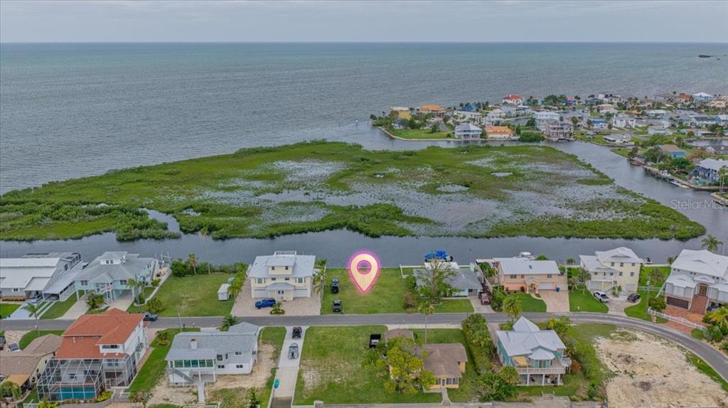 An aerial view shows a vacant waterfront lot marked with a pin near residential homes — 4181 ORCHID DRIVE, HERNANDO BEACH, FL