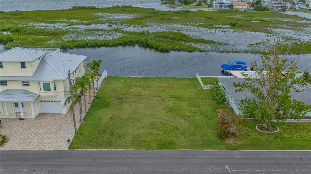 An aerial view shows a vacant waterfront lot situated between two residential houses — 4181 ORCHID DRIVE, HERNANDO BEACH, FL
