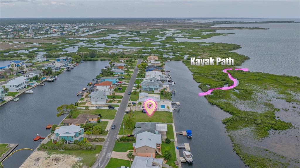 An aerial view shows a waterfront house with a marked kayak path through the marsh — 4181 ORCHID DRIVE, HERNANDO BEACH, FL
