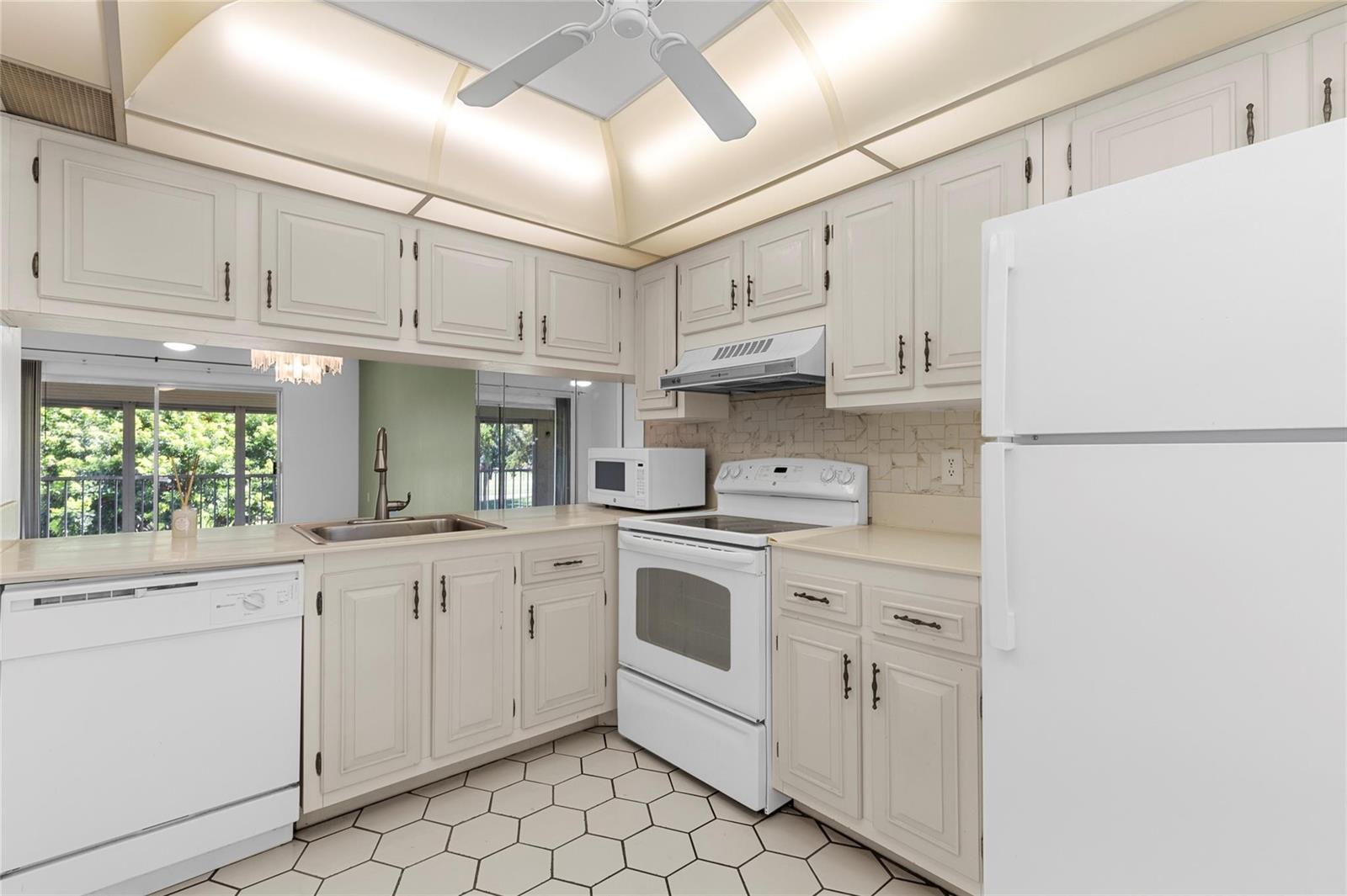 A kitchen with white cabinets, white appliances, a tiled floor, and a ceiling fan — 2701 Nassau Bend # D2, Coconut Creek FL 33066, COCONUT CREEK, FL