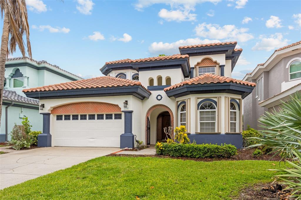 A two-story stucco house with a tile roof, a two-car garage, and a front entrance — 5595 S HIGHWAY A1A, MELBOURNE BEACH, FL