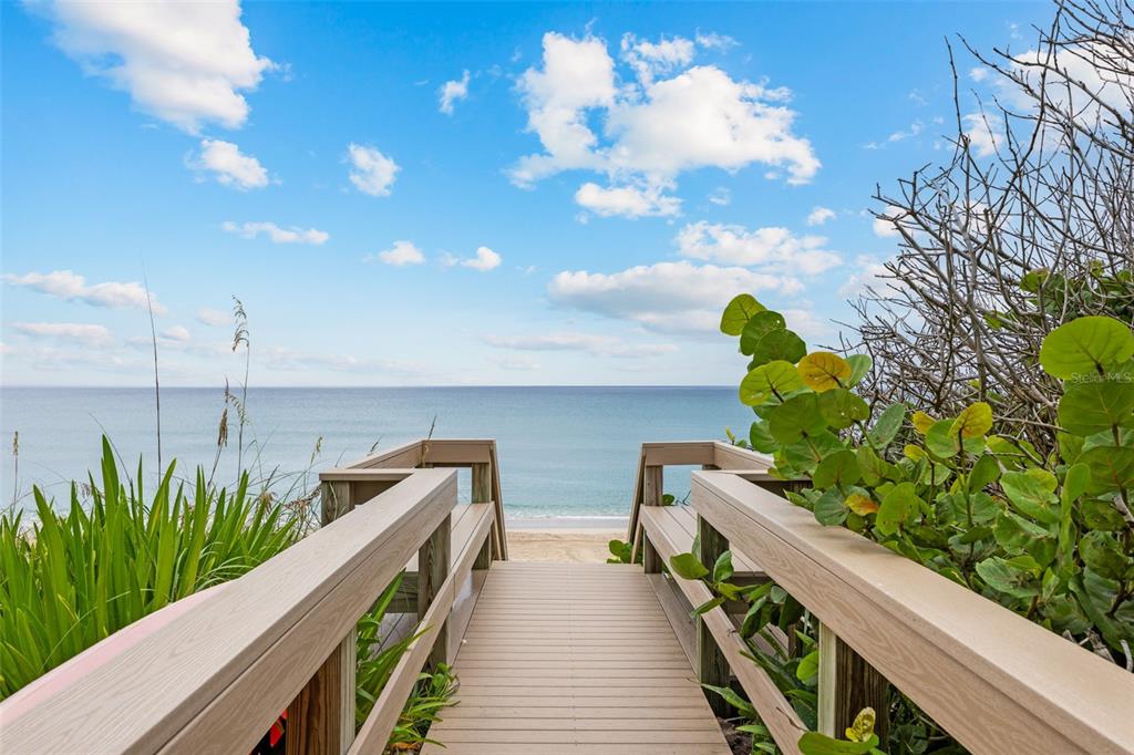 A wooden boardwalk leads toward a sandy beach and the ocean under a blue sky — 5595 S HIGHWAY A1A, MELBOURNE BEACH, FL