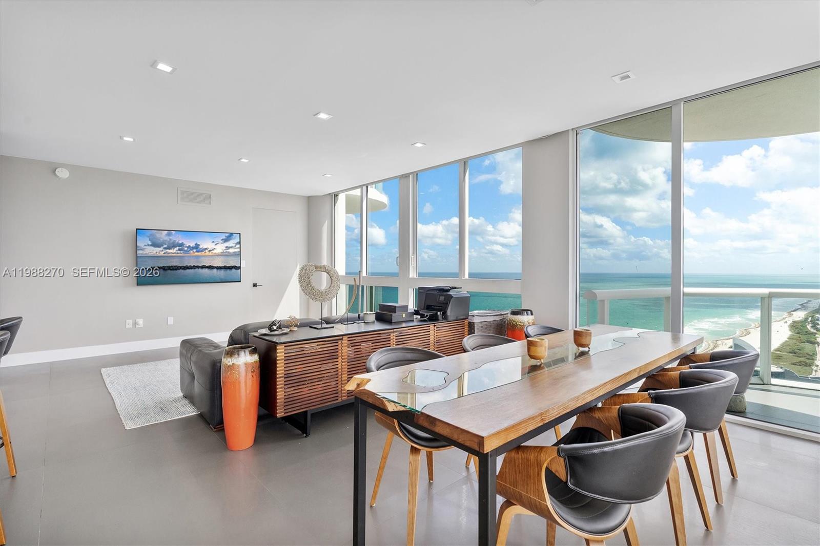 A modern dining and living area features floor-to-ceiling windows with expansive ocean views — 6365 Collins Ave # 4307, Miami Beach FL 33141, MIAMI BEACH, FL