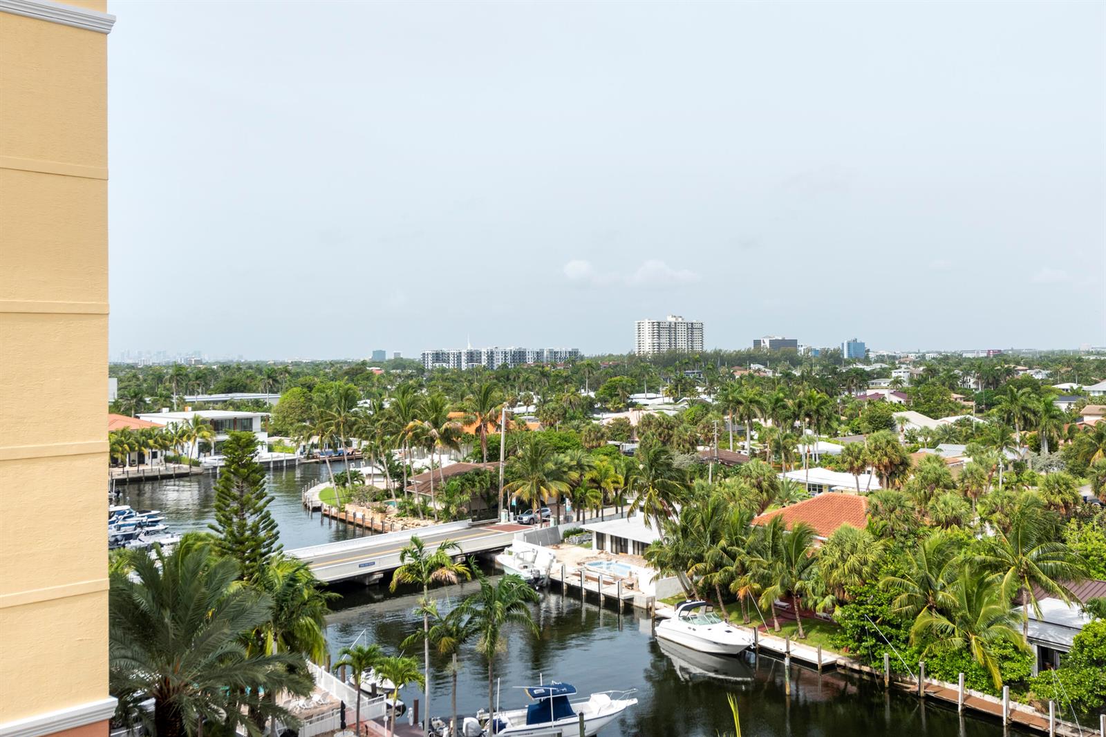 An elevated view of a canal with boats, a bridge, and surrounding tropical residential buildings — 1391 S Ocean Boulevard # 801, Pompano Beach FL 33062, POMPANO BEACH, FL