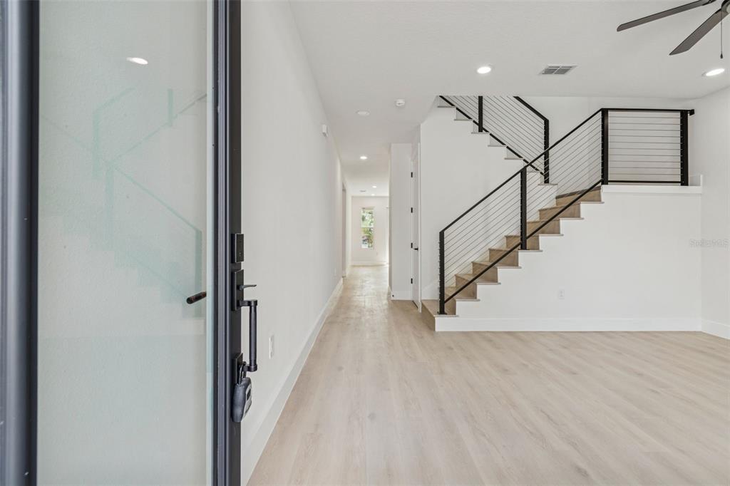 An interior view of a modern home featuring light wood floors and a metal staircase — 1515 E 27TH AVENUE, TAMPA, FL