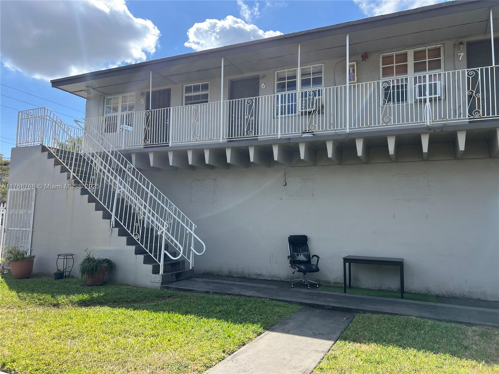 A two-story apartment building exterior features an outdoor staircase leading to a second-floor balcony — 5100 NW 23rd Ave # 5, Miami FL 33142, MIAMI, FL