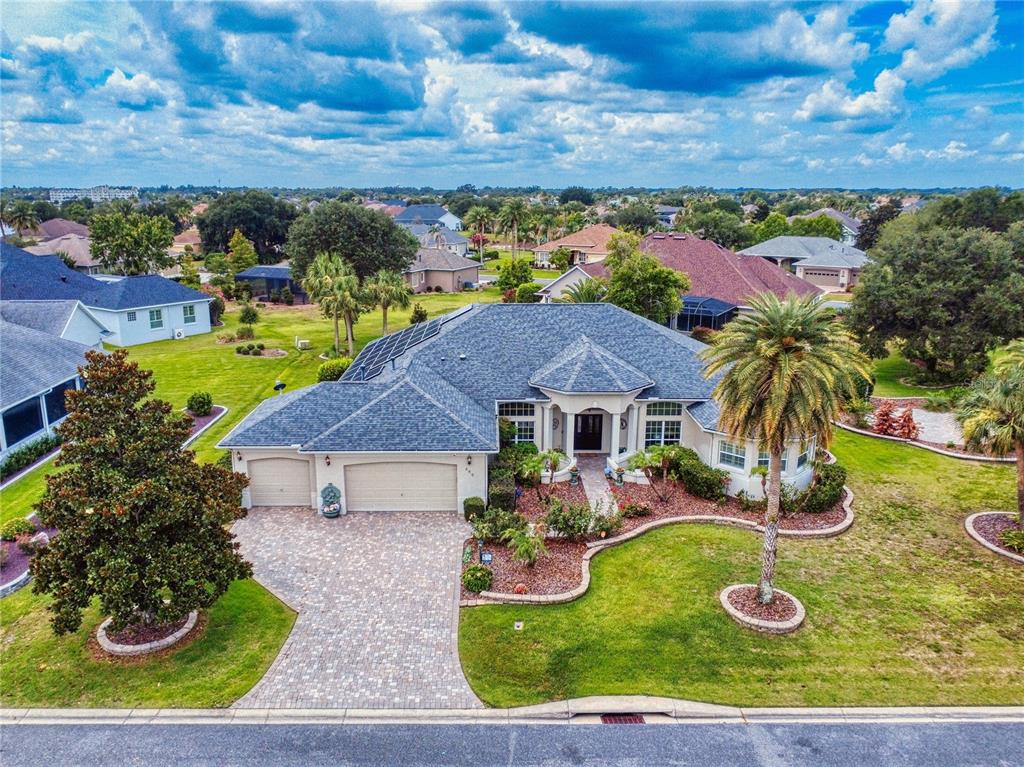 An aerial view of a single-story house with a paved driveway and solar panels — 649 TERNBERRY FOREST DRIVE, THE VILLAGES, FL