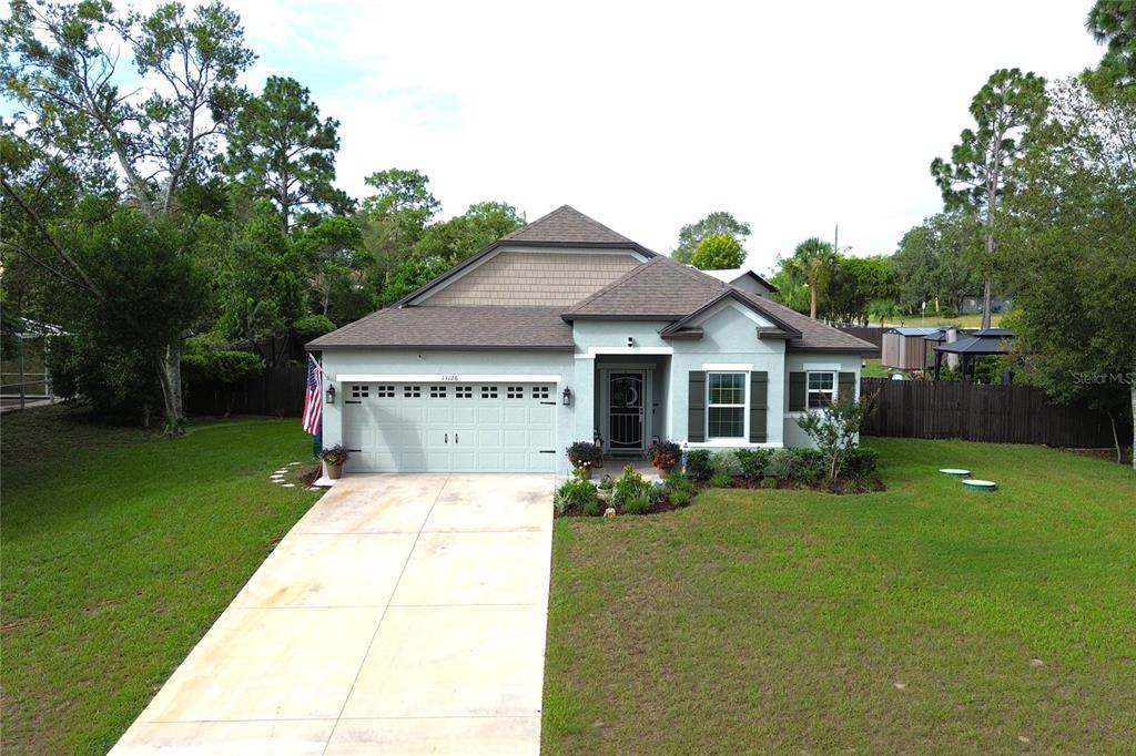 An aerial view of a single-story house with a light green exterior and attached garage — 13126 SANTEE STREET, SPRING HILL, FL