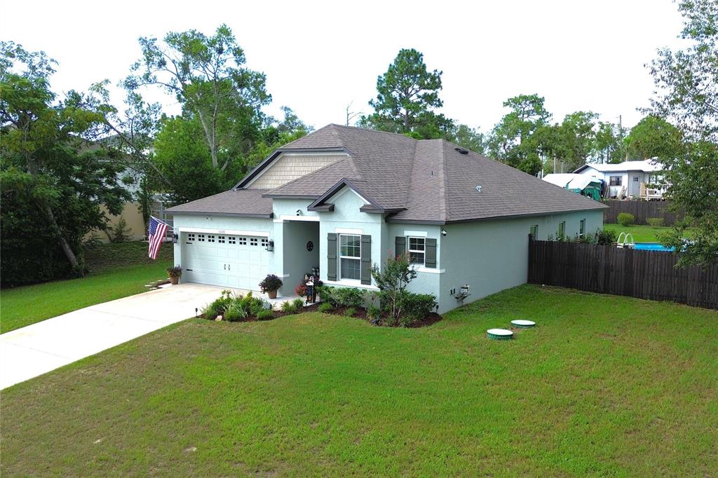 An aerial view of a single-story house with a light green exterior and attached garage — 13126 SANTEE STREET, SPRING HILL, FL
