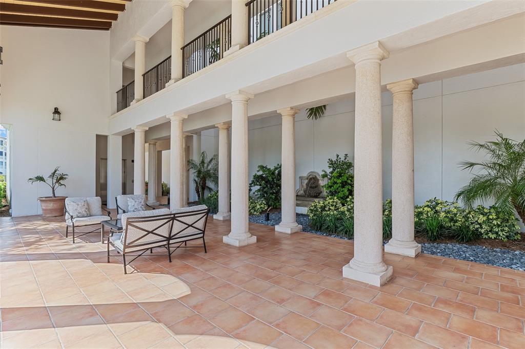 A covered outdoor patio features stone columns, tile flooring, and a small garden area — 11200 HACIENDA DEL MAR BOULEVARD UNIT 306, PLACIDA, FL