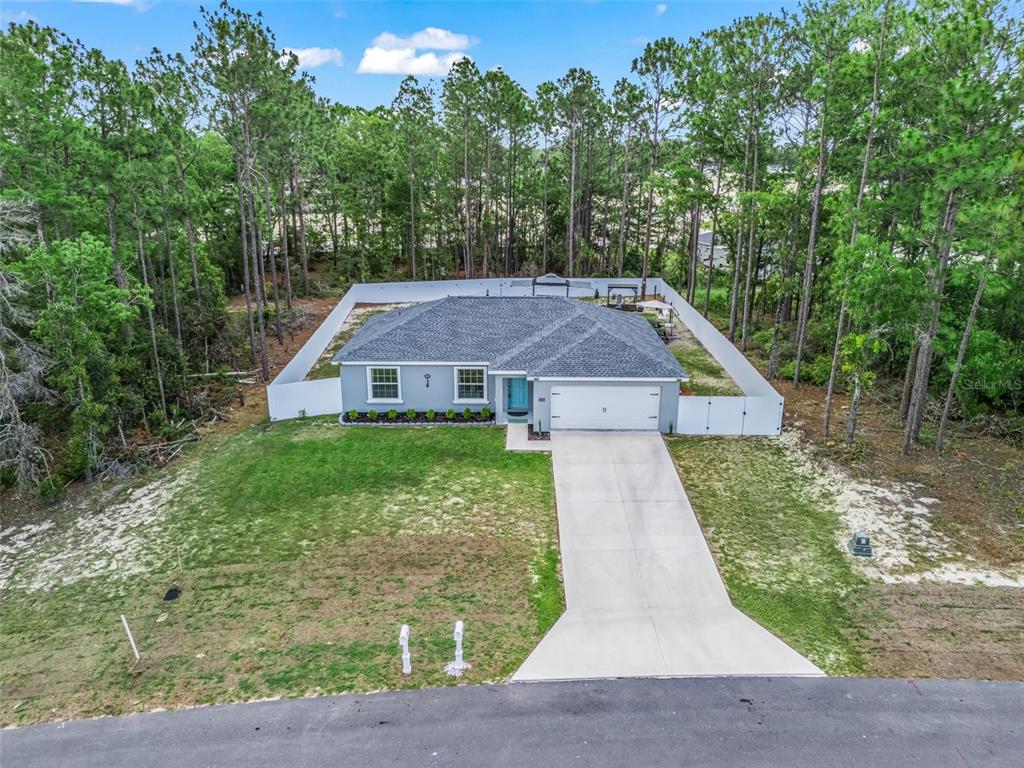 An aerial view shows a single-story house with a white fence and a concrete driveway — 15255 SW 50TH AVENUE ROAD, OCALA, FL