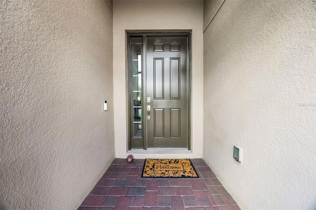 A front entryway features a dark brown door with a sidelight and a brick floor — 2000 GOBLET COVE STREET, KISSIMMEE, FL