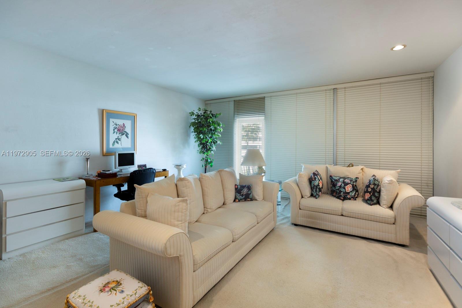 A living room features two beige sofas, a desk, and large windows with white blinds — 1408 Brickell Bay Dr # 414, Miami FL 33131, MIAMI, FL